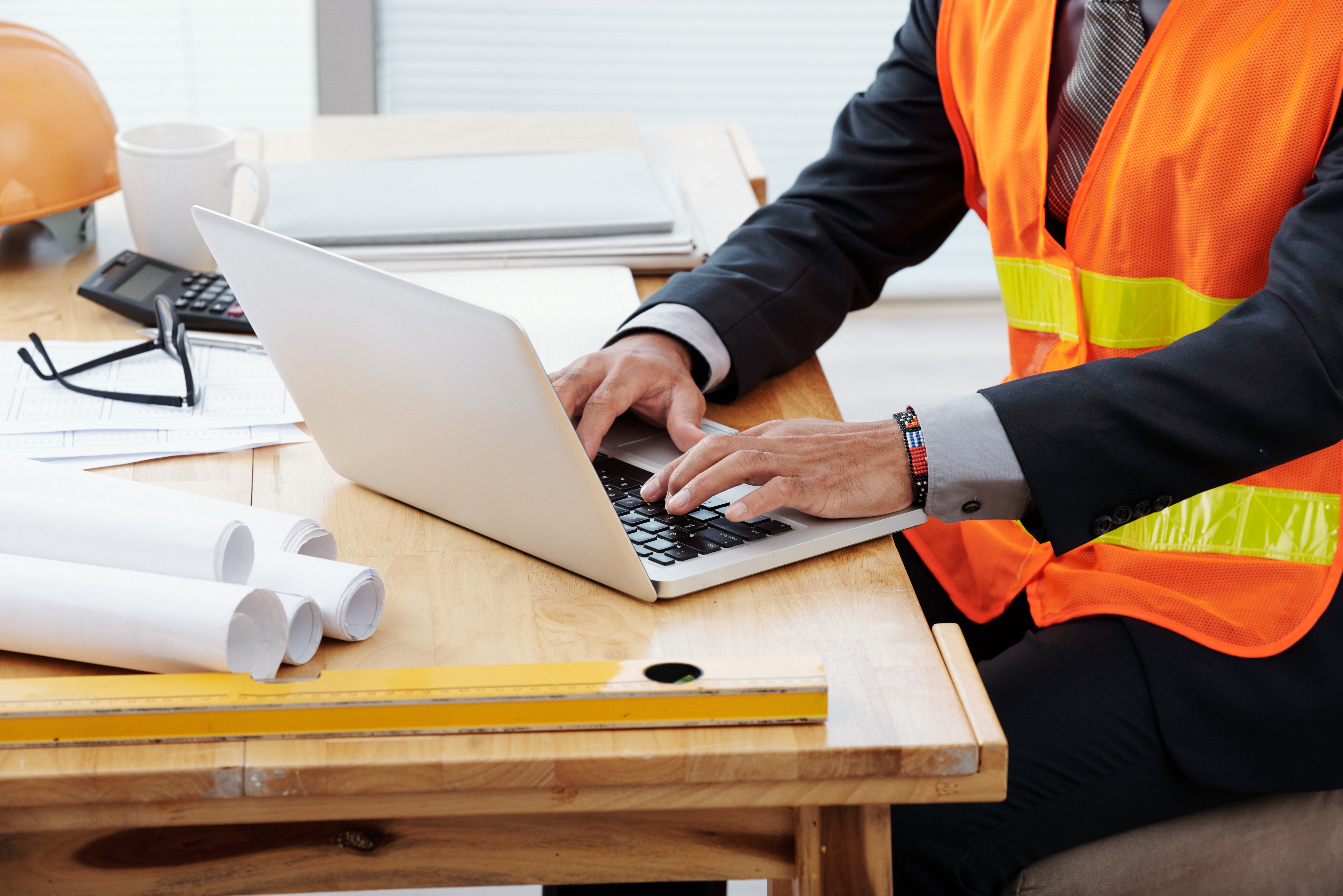 Cropped image of engineer working on laptop in his office
